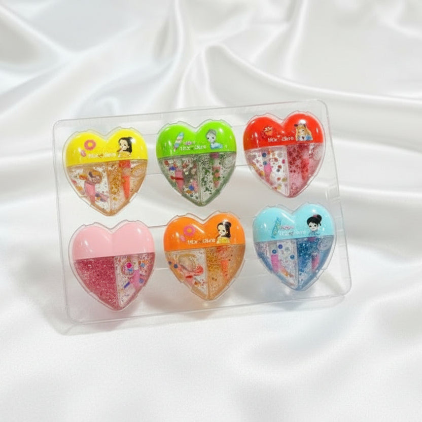 Set of heart-shaped stationery items in clear packaging on a white fabric background